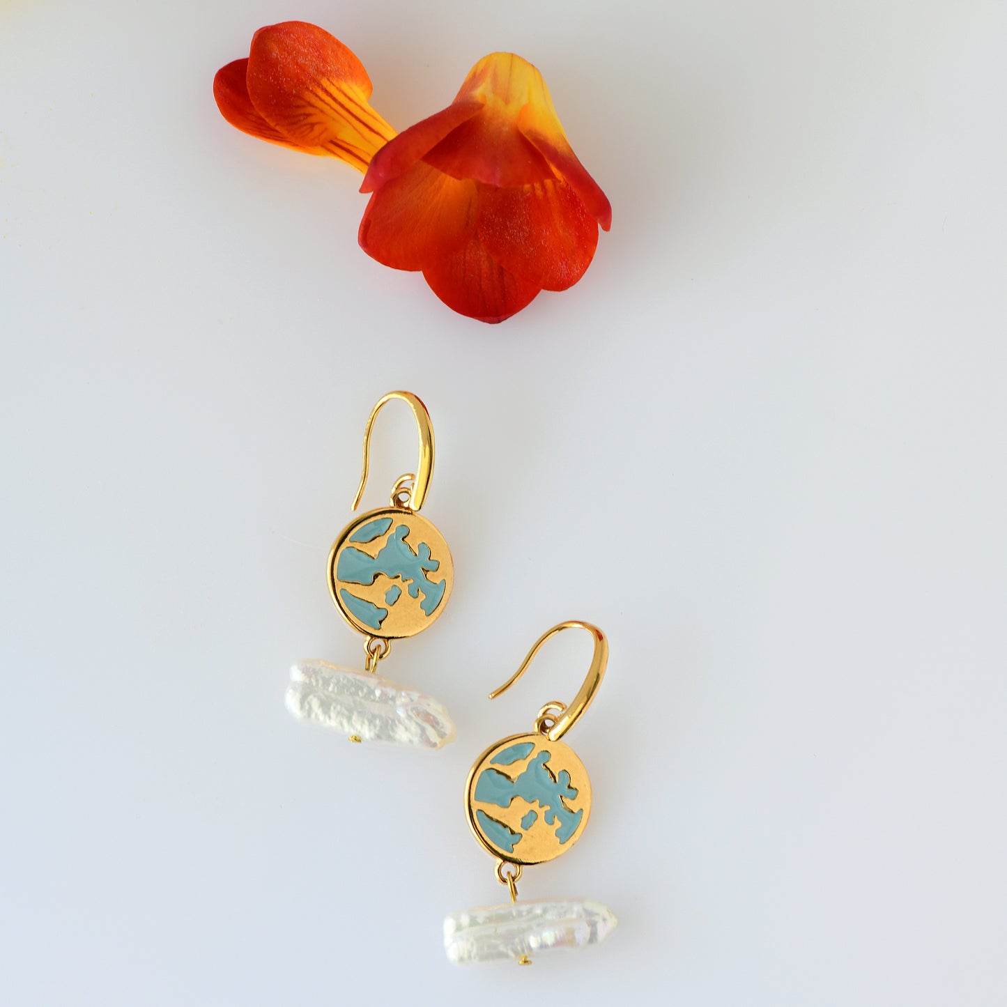 24k gold plated earrings with natural fresh water pearls hanging , and blue enamel